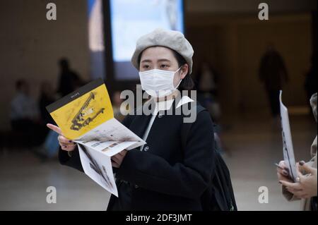 Les touristes portent des masques médicaux au Louvre par mesure de précaution contre le coronavirus à Paris, France, le 4 mars 2020. Le musée du Louvre a rouvert ses portes mercredi après que la direction ait pris des mesures pour apaiser les craintes du personnel au sujet de la propagation du coronavirus, qui avait déclenché un arrêt de travail de deux jours. Dans une déclaration, le musée le plus visité au monde a déclaré que, face aux « préoccupations légitimes » du personnel sur la COVID-19, il avait accepté de prendre des « mesures supplémentaires » pour assurer la sécurité des employés et des visiteurs. Photo de Magali Cohen/ABACAPRESS.COM Banque D'Images