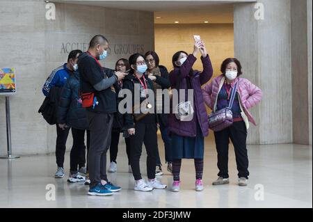 Les touristes portent des masques médicaux au Louvre par mesure de précaution contre le coronavirus à Paris, France, le 4 mars 2020. Le musée du Louvre a rouvert ses portes mercredi après que la direction ait pris des mesures pour apaiser les craintes du personnel au sujet de la propagation du coronavirus, qui avait déclenché un arrêt de travail de deux jours. Dans une déclaration, le musée le plus visité au monde a déclaré que, face aux « préoccupations légitimes » du personnel sur la COVID-19, il avait accepté de prendre des « mesures supplémentaires » pour assurer la sécurité des employés et des visiteurs. Photo de Magali Cohen/ABACAPRESS.COM Banque D'Images