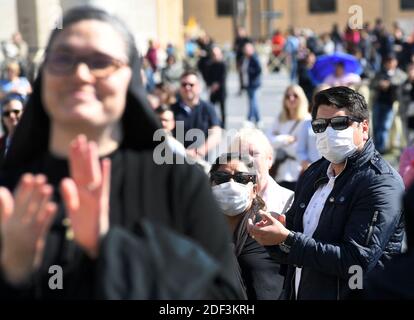 Les gens regardent le pape François livrer la prière Angelus sur un écran géant de la place Saint-Pierre au Vatican le 8 mars 2020. Le pape François a délivré sa bénédiction du dimanche sur Internet depuis l'intérieur du Vatican au lieu d'une fenêtre pour empêcher la foule de se rassembler pendant l'épidémie de coronavirus en Italie. Le pape François a exprimé sa solidarité avec les victimes du nouveau coronavirus dans sa première prière et message en direct du Vatican. Photo: Eric Vandeville/ABACAPRESS.COM Banque D'Images