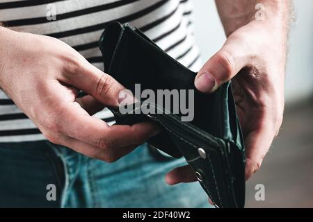Portefeuille vide entre les mains des hommes comme symbole de crise financière et de mauvaise économie. Banque D'Images