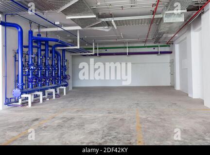 Garage de stationnement intérieur, bâtiment industriel, borne d'eau avec tuyaux d'eau et équipement d'extincteur, vanne de tuyau d'eau, tuyau pour système de tuyauterie d'eau Banque D'Images