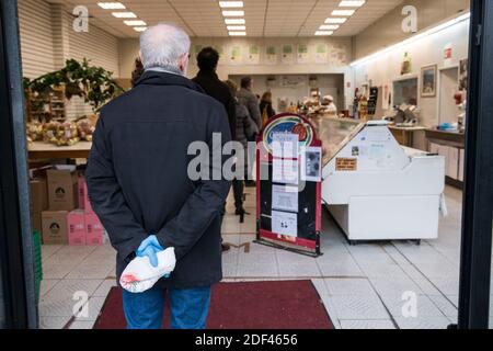 Un homme utilise des gants alors qu'il tient un sac à l'extérieur d'un boucherie le 20 mars 2020 à Wattignies, pendant la COVID-19 comme un verrouillage strict entre en vigueur pour arrêter la propagation de la maladie du coronavirus. Photo de Julie Sebadelha/ABACAPRESS.COM Banque D'Images