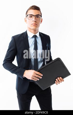 Homme d'affaires en costume noir et lunettes, avec dossier en main, souriant, isolé sur fond blanc Banque D'Images