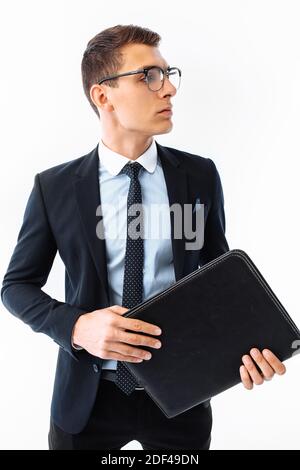 Homme d'affaires en costume noir et lunettes, avec dossier en main, souriant, isolé sur fond blanc Banque D'Images