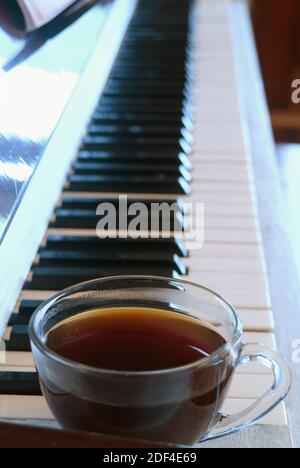 Image verticale d'une tasse de gros plan de café chaud sur le Piano Banque D'Images