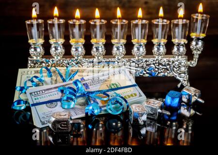 Cadeau en espèces avec menorah brûlante pour Hanoukkah. Vacances juives. Banque D'Images