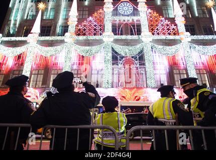 New York, États-Unis. 03ème décembre 2020. Les policiers de NYPD photographient le spectacle de lumière des fêtes à Saks 5th Avenue après que les lumières des arbres de Noël ont été allumées pour la première fois lors de la 88e cérémonie annuelle d'éclairage des arbres de Noël du Rockefeller Center au Rockefeller Center à New York, le mercredi 2 décembre 2020. Photo de John Angelillo/UPI crédit: UPI/Alay Live News Banque D'Images