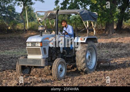 TIKAMGARH, MADHYA PRADESH, INDE - 24 NOVEMBRE 2020 : agriculteur indien avec tracteur préparant des terres pour semis avec herse. Banque D'Images