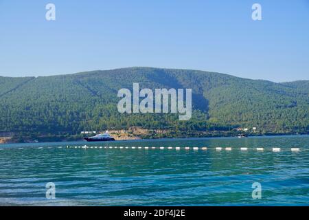 Panorama de la plage de sable avec de magnifiques rochers, palmiers et un voilier dans la mer turquoise sur l'île Paradise. Banque D'Images