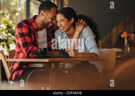 Un jeune couple souriant s'amuser dans un restaurant. Beau couple à un rendez-vous au café-restaurant. Banque D'Images