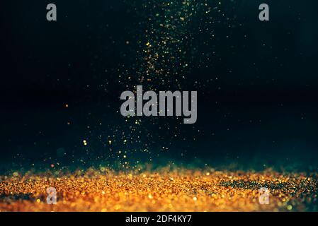 Fond bokeh abstrait scintillant de luxe. Fête du nouvel an et de noël. Lumière poussière étoile dorée étincelante sur fond sombre. Banque D'Images