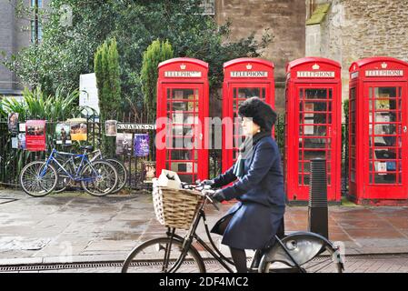 Lady a passé les boîtes de téléphone rouges à Cambridge au Royaume-Uni Banque D'Images