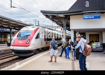 Les passagers se préparent à monter à bord d'un train inclinable à grande vitesse InterCity à la gare Cornavin de Genève. Banque D'Images