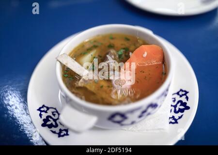 Bol avec shurpa sur table bleue au restaurant Banque D'Images