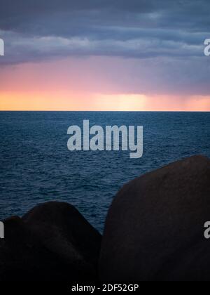 Nuages et pluie au-dessus de la mer atlantique pendant un coloré Coucher de soleil en été en Bretagne (France) Banque D'Images