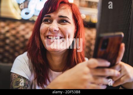 Un portrait en gros plan d'une femme hipster positive tatouée qui fait froid dans un café Banque D'Images