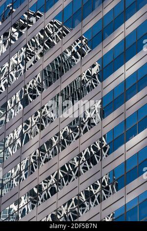 La tour Cocoon mode Gakuen se reflète dans les fenêtres d'une tour de bureau moderne à Shinjuku, Tokyo, Japon Banque D'Images