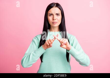 Photo portrait de la femme bouleversée montrant la croix avec les doigts isolés sur fond rose pastel Banque D'Images