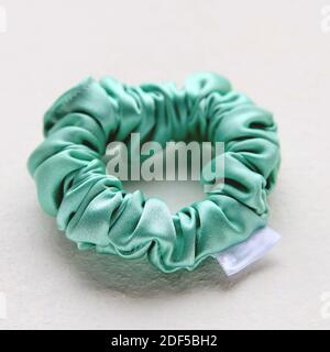 Soie turquoise Scrunchy isolé sur fond blanc. Outil de coiffure de la bande de cheveux élastique colorée, Bobble Scrunchie Hairband. Image carrée Banque D'Images