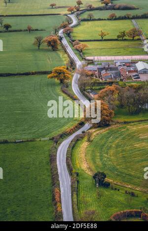 Image verticale longue route venteuse traversant la campagne anglaise dans le Cheshire. Prise de vue aérienne pendant une journée froide en novembre Banque D'Images