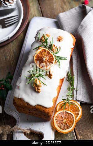 Gâteau aux fruits saupoudrés de glace, de noix et d'orange sec sur fond de bois ancien. Noël et les vacances d'hiver gâteau fait maison Banque D'Images