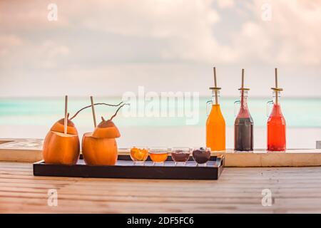 Des cocktails tropicaux colorés sont servis près de la piscine, sur fond de bleu chaud. Vacances d'été exotiques, fête au bord de la piscine avec vue sur la mer Banque D'Images