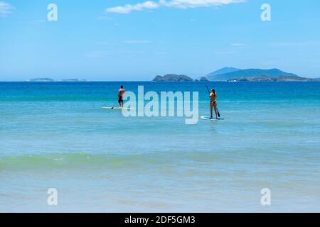 Plage de Geriba, Buzios, Rio de Janeiro, Brésil – 22 décembre 2019 : stand up paddle board (SUP) sur la côte sud de l'atlantique. Couple isolé faisant de l'aquati Banque D'Images