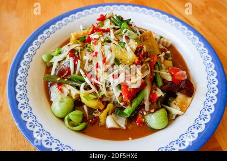 Cuisine thaïlandaise vue du dessus, salade de papaye épicée avec des herbes de yardlong haricots et épices ingrédients Chili tomate ail d'arachide servi sur la table Banque D'Images