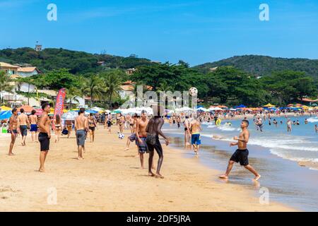 Plage de Geriba, Buzios, Rio de Janeiro, Brésil – 22 décembre 2019 : groupe d'hommes qui s'amusent au football sur la plage. Beaucoup de gens autour d'eux. P Banque D'Images