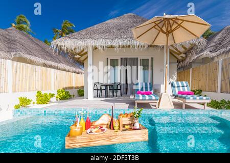 Petit déjeuner dans la piscine, petit déjeuner flottant dans un luxueux complexe tropical. Table de détente sur l'eau de piscine calme, assiette de fruits de petit déjeuner sain, luxe Banque D'Images