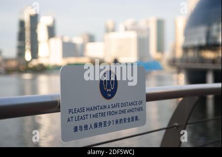 02.12.2020, Singapour, République de Singapour, Asie - UN signe de distance sécuritaire est visible sur une main courante au bord de l'eau de Marina Bay. Banque D'Images