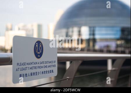 02.12.2020, Singapour, République de Singapour, Asie - UN signe de distance sécuritaire est visible sur une main courante au bord de l'eau de Marina Bay. Banque D'Images