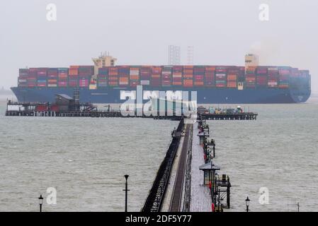 Southend Pier, Southend on Sea, Essex, Royaume-Uni. 3 décembre 2020. Le HMM Rotterdam est un navire conteneur de classe Algeciras, un groupe de douze navires cargo qui peuvent également transporter le plus grand nombre de conteneurs par n'importe quel navire dans le monde, à près de 24,000 conteneurs. Le HMM Rotterdam de 400 m de long et de 232 000 tonnes est entré en service en juin 2020 et effectuera des trajets réguliers entre l'Asie et l'Europe. Il a quitté le port de la DP World London Gateway dans la Tamise à Stanford le Hope, dans l'Essex, en direction de la mer du Nord et est vu s'élevant au-dessus de Southend Pier Banque D'Images