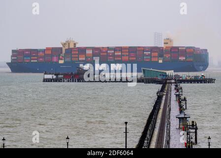 Southend Pier, Southend on Sea, Essex, Royaume-Uni. 3 décembre 2020. Le HMM Rotterdam est un navire conteneur de classe Algeciras, un groupe de douze navires cargo qui peuvent également transporter le plus grand nombre de conteneurs par n'importe quel navire dans le monde, à près de 24,000 conteneurs. Le HMM Rotterdam de 400 m de long et de 232 000 tonnes est entré en service en juin 2020 et effectuera des trajets réguliers entre l'Asie et l'Europe. Il a quitté le port de la DP World London Gateway dans la Tamise à Stanford le Hope, dans l'Essex, en direction de la mer du Nord et est vu s'élevant au-dessus de Southend Pier Banque D'Images