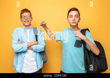 L'adolescent domine frère, poing, sur fond jaune Banque D'Images