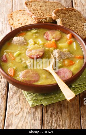 Soupe de pois fendus avec légumes, saucisses fumées et porc dans l'assiette sur la table. Verticale Banque D'Images