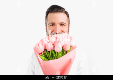 Homme élégant avec une barbe qui tient un bouquet de tulipes, un cadeau pour la Saint-Valentin. Sur fond blanc Banque D'Images