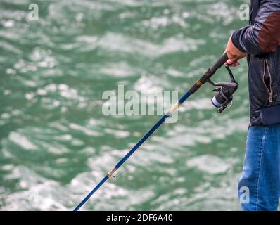 Pêcheur tenant une canne à pêche. Homme pêche. Banque D'Images