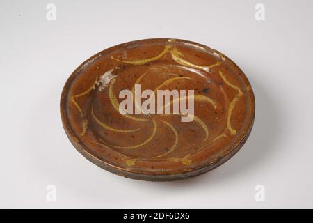 Assiette de vaisselle, Anonyme, première moitié du XVIe siècle, glaçure de plomb, faïence, général: 4.2 x 18.6 cm, 42 x 186 mm, plaque de faïence rouge, recouverte de glaçure de plomb sur le devant. La plaque est dotée d'un fond rond et d'un bord d'épandage avec un bord profilé et repose sur trois pattes à lobes. L'étagère est décorée d'une décoration de boue jaune d'un tourbillon de huit rayons, et sur le bord de quatre motifs en forme de V. Écrit en bas: Lakenhal Leiden, 1913 Banque D'Images