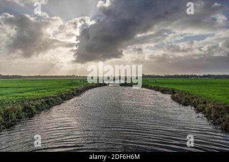 Ciel nuageux spectaculaire par une journée venteuse au-dessus d'un canal Dans le paysage de polder ouvert entre la Haye et Leiden Aux pays-Bas Banque D'Images