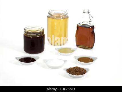 Sucre semoule fine, le sucre brun, sirop d'érable, la mélasse et le miel, le sucre contre fond blanc Banque D'Images
