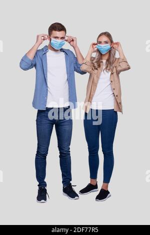 Couple met sur le masque médical debout isolé. Protection de la santé, soins médicaux, couple, famille, concept de virus Banque D'Images