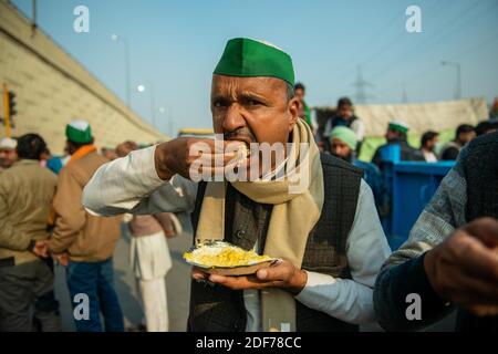 New Delhi, Inde. 03ème décembre 2020. Un manifestant mangeant des repas pendant la manifestation.des agriculteurs de tous les États protestent dans les camps frontaliers de Delhi-Uttar Pradesh sur la National Highway-9 dans le cadre de la protestation contre les nouvelles réformes agricoles du gouvernement central. Crédit : SOPA Images Limited/Alamy Live News Banque D'Images