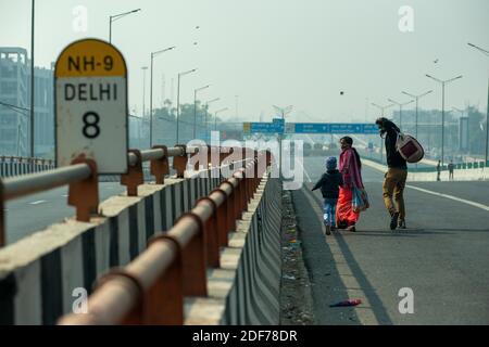 New Delhi, Inde. 03ème décembre 2020. Une famille marchant sur une route vide en direction de Delhi pendant la manifestation.des agriculteurs de tous les États protestent dans les camps frontaliers de Delhi-Uttar Pradesh sur la National Highway-9 dans le cadre de la protestation contre les nouvelles réformes agricoles du gouvernement central. Crédit : SOPA Images Limited/Alamy Live News Banque D'Images