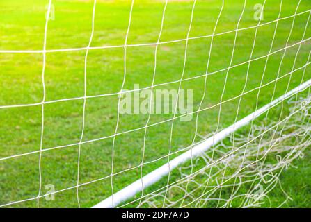 Gros plan sur le filet de but du football avec de l'herbe verte Banque D'Images