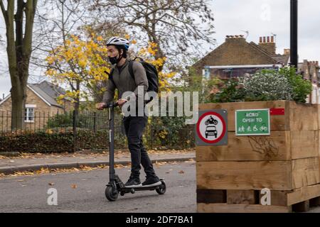 Un homme portant un masque de visage à bord d'un scooter électrique à Brixton le 21 novembre 2020 à Londres au Royaume-Uni. Photo de Sam Mellish