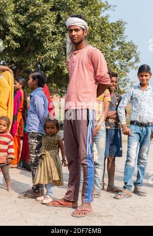 NOIDA, UTTAR PRADESH, INDE - NOVEMBRE 2020 : jeunes enfants pauvres ou étudiants de bidonvilles ou de village se tenant en groupe pour recueillir la nourriture distribuée. Banque D'Images