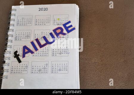 Calendrier de l'année 2020, imprimé sur papier, avec l'inscription échec en lettres découpées, sur fond céramique, vue de haut en bas, avec espace de copie Banque D'Images