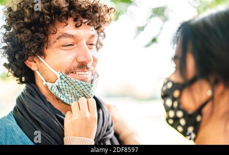 Couple heureux d'amoureux regardant les uns les autres avec ouvert Masque facial - concept d'amour et d'espoir à l'heure du Covid avec le gars et la fille sur le moment de la relation d'appel d'offres Banque D'Images