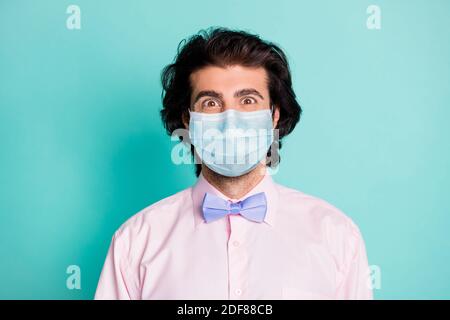 Photo portrait d'un homme souriant à travers un masque de sécurité médical isolé sur fond bleu sarcelle pastel Banque D'Images